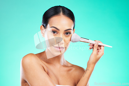 Image of Makeup, cosmetics and portrait of a woman with a brush isolated on a green studio background. Skincare, beauty and face of a model with foundation, powder or cosmetic facial product on a backdrop