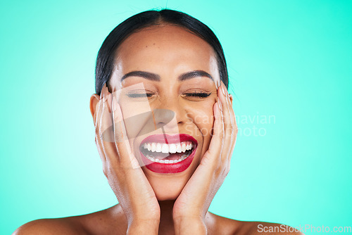 Image of Face, makeup and excited with a model black woman in studio on a blue background for skincare or cosmetics. Beauty, lipstick and satisfaction with a young female posing to promote a cosmetic product