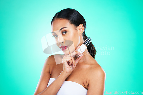 Image of Makeup, beauty and portrait of a woman in studio with facial serum for skincare treatment. Cosmetics, face and female model from Mexico with natural self care routine isolated by turquoise background