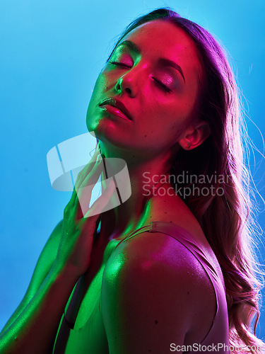 Image of Woman skincare, glowing or neon lighting on isolated blue background and hands on neck, body or skin. Beauty model, touching or creative fantasy with green, pink lights or makeup cosmetics aesthetic