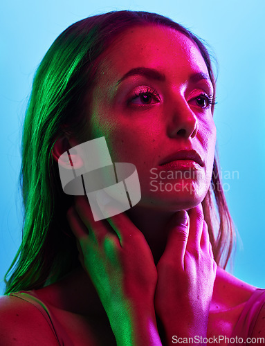 Image of Model skincare, glowing or neon lighting on isolated blue background and hands on neck, body or skin. Beauty, thinking or woman touching in creative fantasy green, pink or lights aesthetic in makeup