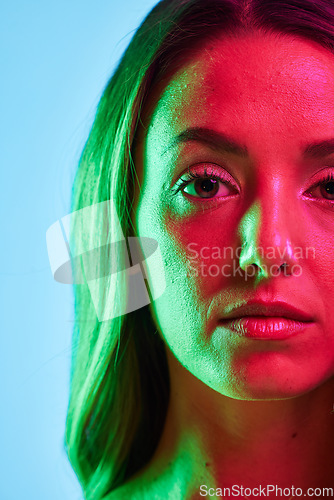 Image of Half portrait, skincare or glowing neon lighting on isolated blue background in self love or healthcare. Zoom, beauty model or woman face in creative fantasy green, pink or lights aesthetic in makeup