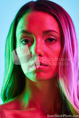 Image of Skincare, portrait or glowing neon lighting on isolated blue background in self love, healthcare or headshot. Beauty model, woman or face in creative fantasy green, pink or lights aesthetic in makeup