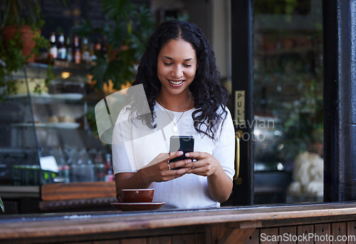 Image of Woman in coffee shop, cellphone and connection for social media, texting and online reading on break. Female, lady and smartphone for typing, communication and girl in cafe, tea and search internet