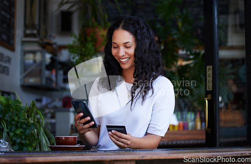Image of Woman, phone and credit card with smile for ecommerce, online shopping or purchase at coffee shop. Happy female shopper on smartphone for internet banking, app or wireless transaction at indoor cafe