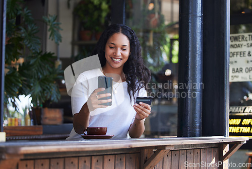 Image of Woman, phone and credit card at coffee shop for ecommerce, online shopping or purchase. Happy female customer with smile on smartphone for internet banking, app or wireless transaction at indoor cafe