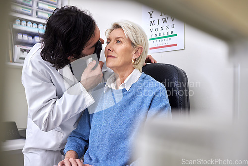 Image of Senior patient in a vision test or eye exam for eyesight by doctor, optometrist or ophthalmologist with medical aid. Mature woman or client with a helpful optician to see retina or check glaucoma