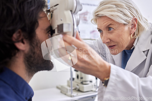 Image of Doctor with a man in vision test or eye exam for eyesight by a focused senior optometrist or ophthalmologist. Optician helping check retina health of a client or happy customer with medical insurance