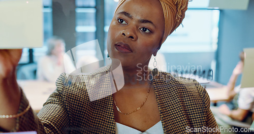 Image of Black business woman, post it and writing planning notes on glass wall for business meeting, presentation training or leadership in modern office. African woman, leader thinking and SEO strategy idea