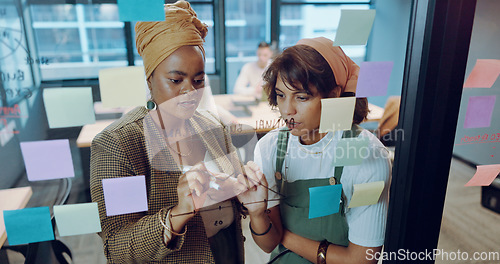 Image of Sticky notes, planning and team writing on a board while analyzing research for a creative project. Collaboration, teamwork and female marketing employees working on advertising strategy in an office