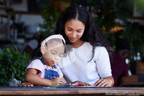 Image of Drawing, learning and mother with girl at cafe, studying and art education at table. Family care, love and mama teaching kid how to color with crayons, having fun and bonding together in restaurant.
