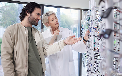 Image of Woman help man with glasses in optometry store, retail shopping and vision services. Optometrist, eye care and choice of frames, new lenses and shelf for customer consulting, health and wellness test