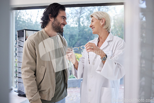 Image of Woman optometrist help man with glasses in optometry store, retail shopping and vision services. Optician, eye care and choice of frames, lenses and happy customer consulting, health or wellness test