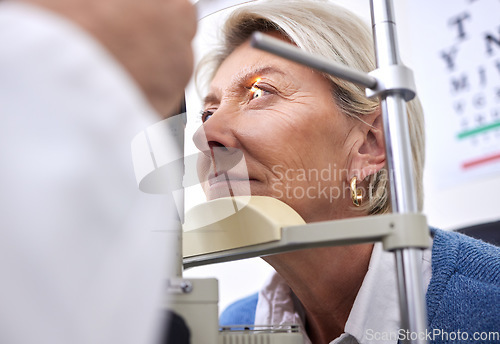 Image of Eye exam, vision or laser test for a woman with a machine at optometry consultation for retina problem. Senior, patient or mature client with medical health insurance checking eyesight at optician