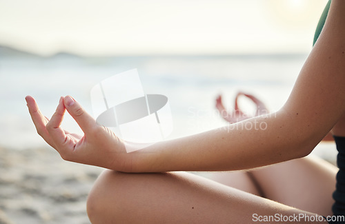 Image of Woman, hands and yoga in meditation on the beach for spiritual wellness or zen workout outdoors. Hand of female yogi relaxing and meditating for calm, peaceful mind or awareness by the ocean coast