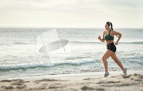 Image of Woman listening to music, running on beach and morning cardio routine for healthy lifestyle in California. Fitness workout by sea, young athlete with headphones and sports exercise in summer mockup