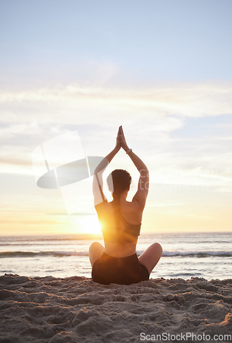 Image of Woman, yoga and meditation on the beach for spiritual wellness or zen workout during sunset. Female yogi relaxing and meditating in sunrise for calm, peaceful mind or awareness by the ocean coast