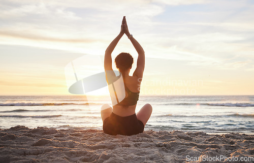 Image of Woman, yoga and meditation on the beach sunset for zen workout or spiritual wellness outdoors. Female yogi relaxing and meditating in sunrise for calm, peaceful mind or awareness by the ocean coast