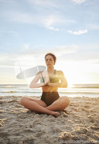 Image of Woman, yoga and meditation on the beach in namaste for spiritual wellness or zen workout in the sunset. Female yogi relaxing and meditating for calm, peaceful mind or awareness by the ocean coast