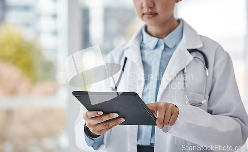 Image of Digital tablet, healthcare and doctor doing research in the hospital for a diagnosis or test results. Technology, career and closeup of a female medical worker on a mobile device in a medicare clinic