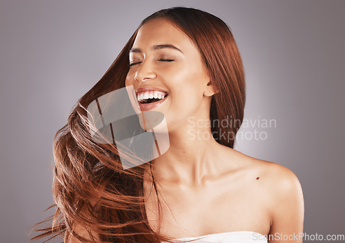 Image of Happy, hair and hairstyle by woman with smooth, glow and healthy skincare isolated in a studio gray background. Young, skin and natural model smile due to keratin treatment for haircare