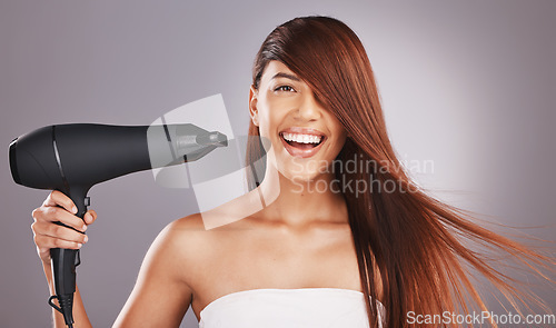 Image of Hair, hairdryer and portrait of woman salon smile, happy and excited isolated against studio gray background. Hairstyle, model and natural beauty female with self care, haircare and drying or styling