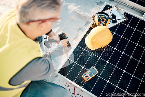 Image of Solar energy, industrial work and senior construction worker on a building roof with panel. Sustainability, electricity and industrial grid with a mature engineer drilling with tools outdoor