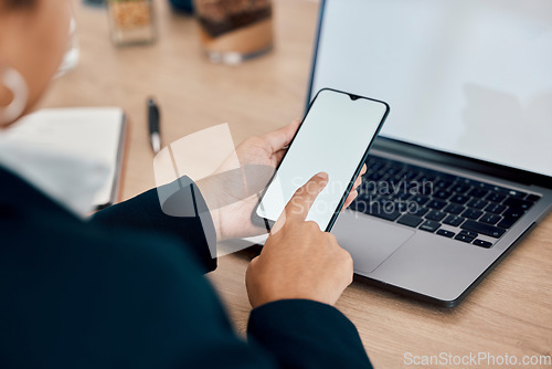 Image of Woman, hands and phone by laptop on mockup for communication, social media or mobile app at office desk. Hand of female touching green screen display on smartphone for online advertising or marketing