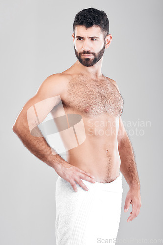 Image of Body, man and skincare with towel, cosmetics and dermatology with hygiene, clean and guy on grey studio background. Male, thinking and hairy gentleman with idea, aesthetics and wellness on backdrop