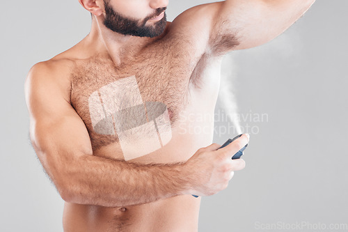 Image of Deodorant, spray and man in studio for hygiene, fresh scent or underarm perfume. Male model spraying armpit for body odor, smell and cleaning cosmetics, shower product and skincare mist on background