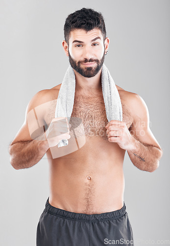 Image of Health, fitness and man with towel on neck after sports workout, sweat and hygiene isolated on grey background. Portrait of coach, personal trainer and smile, body care mindset for exercise in studio