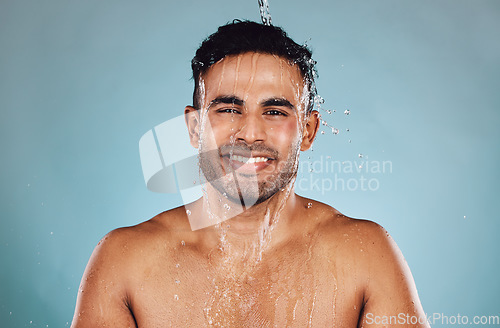 Image of Portrait, wet and man with water, cleaning and hygiene with guy on blue studio background. Face, male and gentleman with liquid, aqua or washing for skincare, morning routine or grooming on backdrop