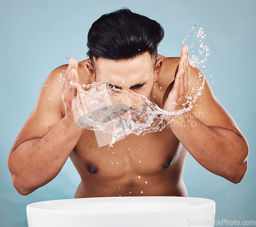 Image of Man, water splash and face wash by basin for skincare, fresh clean hygiene or grooming against a studio background. Young male model in beauty, wellness and washing or cleansing for facial treatment