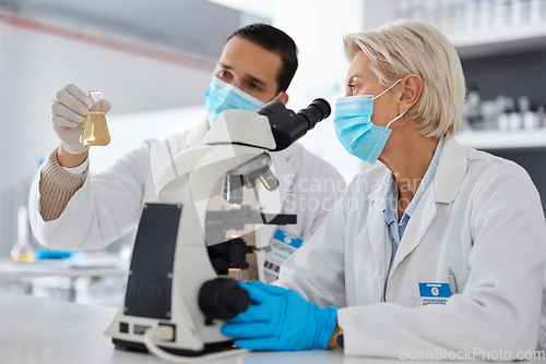 Image of Science, mask and man with woman, liquid and experiment with cure, breakthrough and conversation in laboratory. Female scientist, male research and face cover for protection, safety and test tube