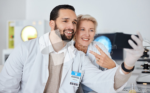 Image of Science team, selfie and smile in lab for research, peace sign and happy at pharma company with phone. Scientist man, woman and profile picture for app, social network and teamwork with happiness