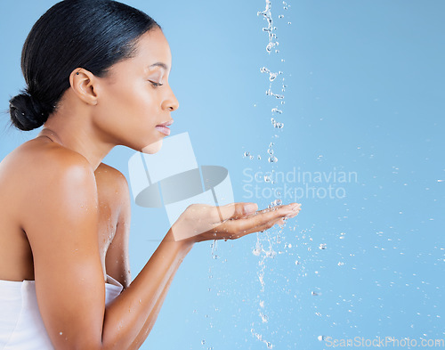 Image of Beauty, water splash or washing hands for skincare grooming, healthcare wellness or sustainability cleaning on blue background. Black woman, model or wet shower drops for facial hydration dermatology