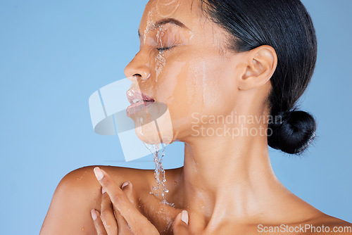 Image of Model, water splash or washing face in shower grooming, healthcare or sustainability cleaning on isolated blue background. Zoom, black woman or beauty in wet drops for skincare hydration dermatology