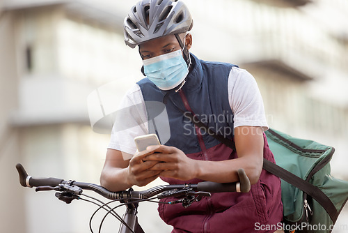 Image of Courier service, delivery and black man with phone, shipping app with face mask for Covid compliance. Eco friendly travel, outdoor and communication with ecommerce and bike, retail and distribution