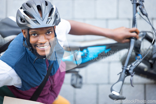 Image of Black man, delivery bicycle and street portrait from top view for logistics, cargo and happy for job. Young african person, bike and shipping service with smile outdoor, helmet and safety in city