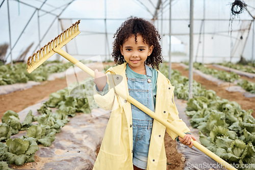 Image of Kid, girl or portrait and farming tool in greenhouse, agriculture land or sustainability field for harvesting. Smile, happy or gardening kid and farmer equipment for soil, lettuce or vegetable growth