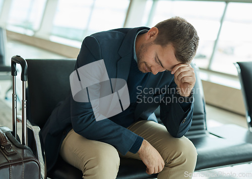 Image of Airport, sad and headache of man waiting to travel, frustrated or depression in transport delay, crisis or problem. Immigration, stress and angry person depressed for flight fail or schedule mistake