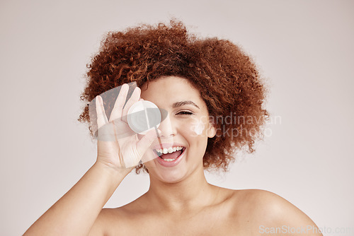 Image of Skincare, beauty and portrait of happy woman with cream container, smile and afro, advertising luxury skin product promotion. Dermatology, cosmetics and facial for model isolated on studio background