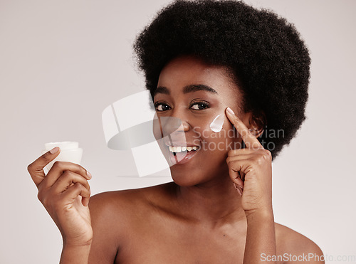 Image of Skincare, product and portrait of black woman with cream on face, smile and advertising skin care promotion. Dermatology, cosmetics and facial for happy model with jar isolated on studio background.