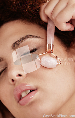 Image of Skin care, face roller and woman doing massage in studio with dermatology and cosmetic tools. Aesthetic model with hands for spa facial product for health, wellness and natural skin youth glow