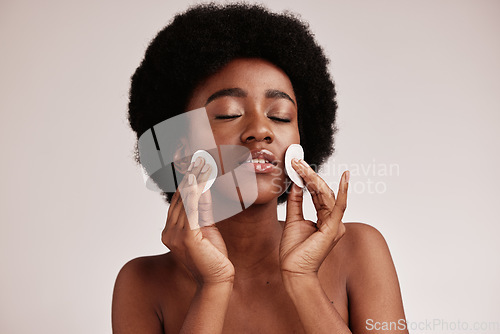 Image of Skin care, cotton and cleaning face of black woman in studio with dermatology, cosmetic and detox. Aesthetic model with hands on natural facial skin for makeup remover, beauty and wellness for spa