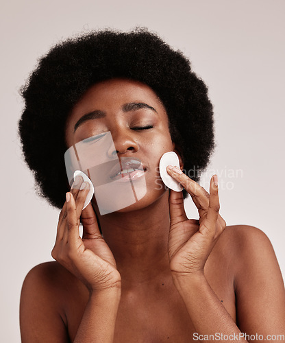 Image of Black woman, skin care and cotton for cleaning face in studio with dermatology, cosmetic and detox. Aesthetic model with hands on natural facial skin for makeup removal, beauty and wellness for spa