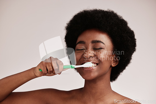 Image of Brushing teeth, toothbrush and black woman for cleaning mouth on studio background. Face of happy person advertising dentist tips for dental care, hygiene and clean smile for healthy lifestyle