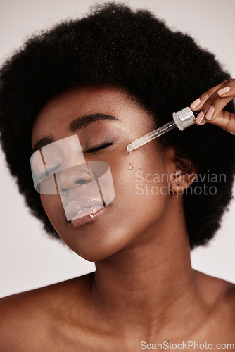 Image of Face serum, skin care and beauty of black woman in studio with dermatology cosmetic oil. Aesthetic model with hands for collagen product for health, wellness and facial skin natural youth glow