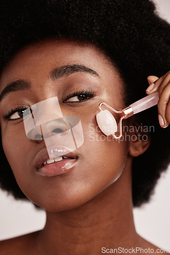 Image of Face roller, skin care and black woman facial massage in studio with dermatology and cosmetic tools. Aesthetic model with hands for spa product for health, wellness and natural youth skin glow