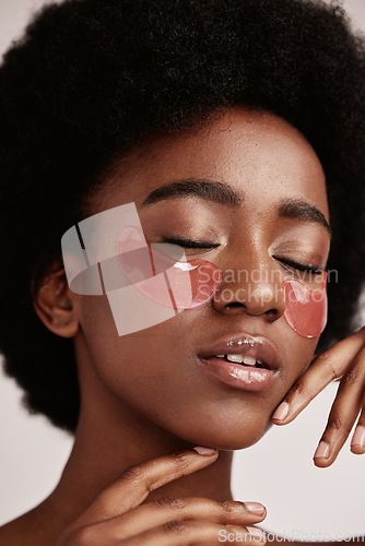 Image of Black woman with skincare, eye or face mask in studio with dermatology cosmetic product. Aesthetic model with hand on skin for spa collagen beauty patch for health, wellness and natural facial glow